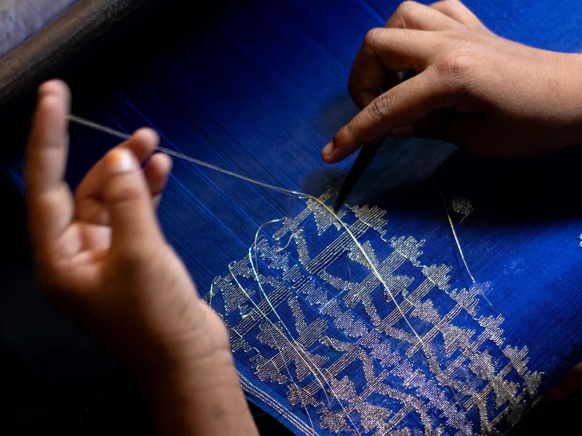 Weaver's hands working a Jamdani loom