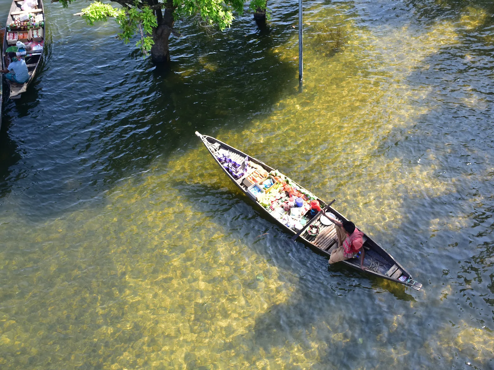 A boat on the clear emerald water of Tanguar Haor